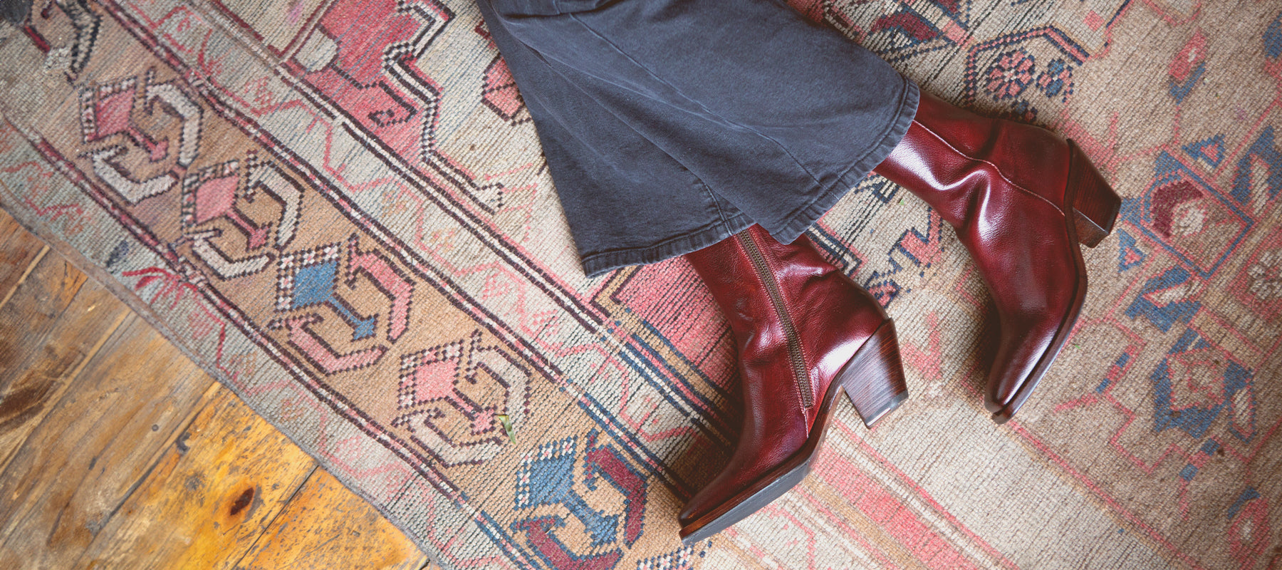 A beautiful red leather Italian made boot showcased on a rustic wool rug