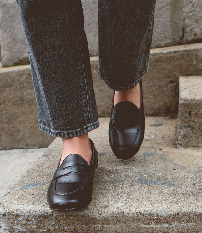 Person sporting Bed Stu Ballet and cuffed jeans, descending concrete steps with an air of comfort and flexibility.