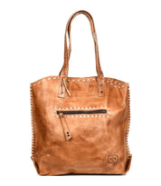 The Bed Stu Barra is a handmade leather tote bag featuring two handles, a front zipper pocket, contrast stitching along the edges, and a small embossed logo near the bottom corner.
