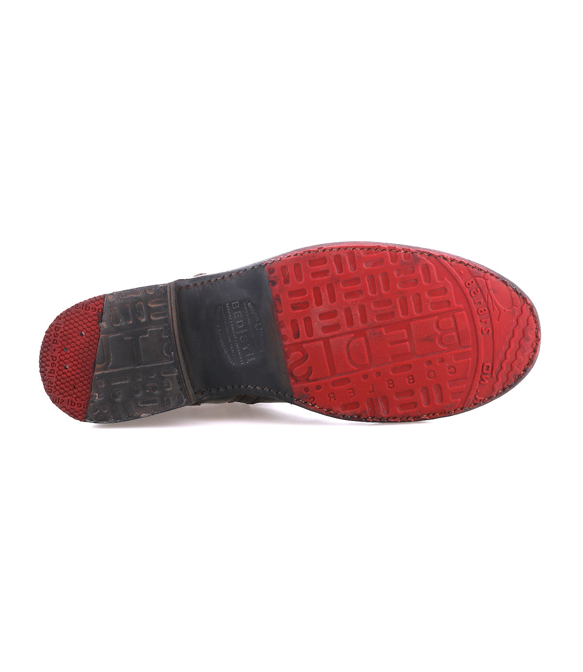 The Bed Stu Becca features a textured red and black rubber sole with multiple grip patterns, echoing the durability and style of a short engineer boot.