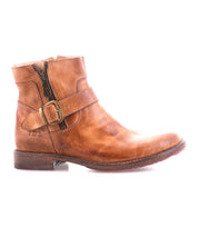 The Bed Stu Becca is a brown leather short engineer boot with an ankle buckle, side zipper, and buckle strap, shown solo against a white background.