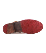The Bed Stu Becca boot features a red rubber sole with raised pattern, a brown leather heel section, and dual zippers for style and convenience.