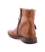 The Bed Stu Becca is a brown leather short engineer boot featuring dual zippers and an ankle buckle, shown from the back and side against a white background.