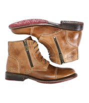 The Bed Stu Bonnie II is a pair of tan leather combat ankle boots featuring cap toes, side zippers, lace-up fronts, dark brown soles, and red tread on the bottom.