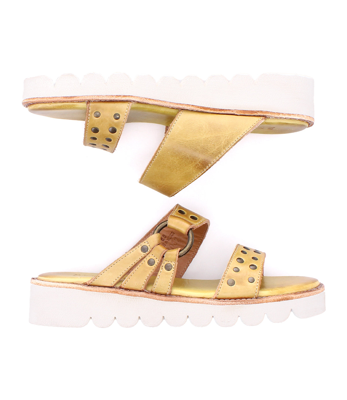 Bed Stu Chow gold and tan slip-on sandals with cushioned footbed and white scalloped chunky rubber soles, shown with one sandal facing up and the other facing down.