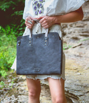 A woman in a white dress holding a Bed Stu Commuter.