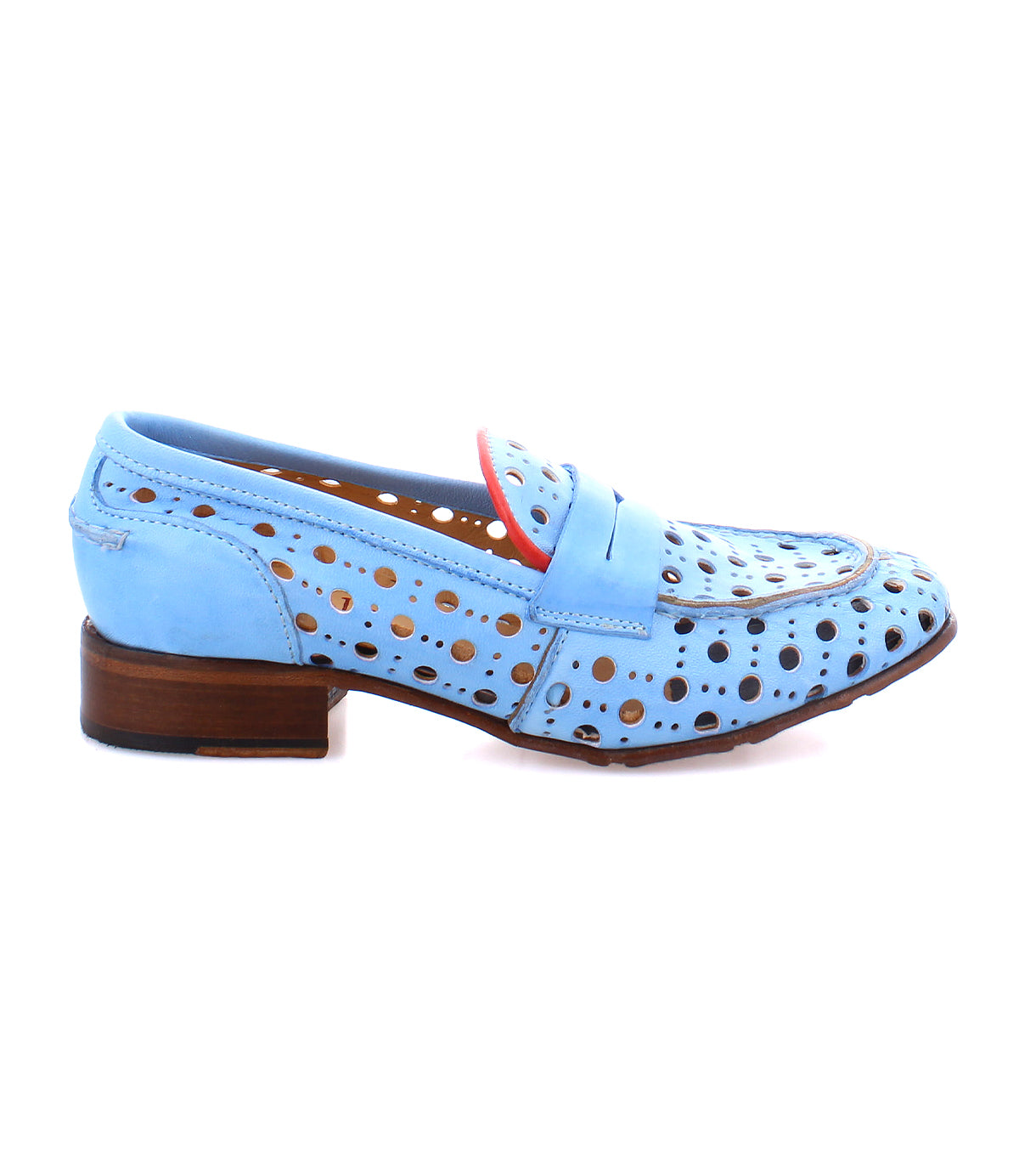 The Cornflower by Bed Stu is a light blue perforated leather penny loafer with a playful circular cutout pattern and a red accent along the opening, featuring a brown stacked heel. Handcrafted for style and comfort.