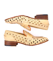 A pair of beige Cornflower loafers by Bed Stu with a playful circular cutout pattern, wooden heels, and leather straps. Handcrafted penny loafers are shown from the side, with one shoe upside down above the other.