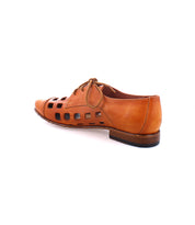 A tan leather shoe, handcrafted in Italy, featuring a playful lace-up design and bold square cut-out patterns on the sides, displayed on a white background. The product is called Decoy by Bed Stu.