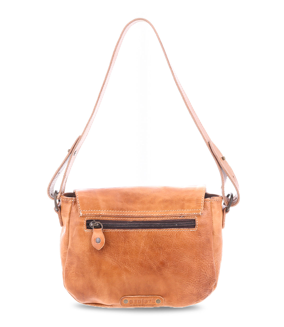 The Bed Stu Elect is a vintage-style brown leather handbag featuring a top flap, front zip pocket, an adjustable strap for ultimate comfort, and a distinctive embossed logo at the bottom.
