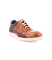 The Fairman sneaker by Bed Stu is a brown leather low-top with a sleek white sole, featuring perforations and unique topstitching, effortlessly combining style and comfort.