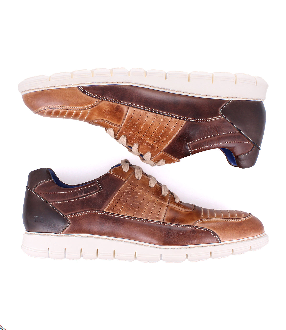 Two Fairman low-top leather sneakers by Bed Stu, featuring unique topstitching and perforated sides with a 3-tone brown finish and white soles, viewed from the side with toes facing opposite directions.