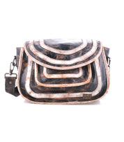The Bed Stu Gilda is a spacious leather shoulder bag with a flap closure, adorned with layered arc designs in brown, black, and metallic hues—a stylish and functional crossbody for everyday use.