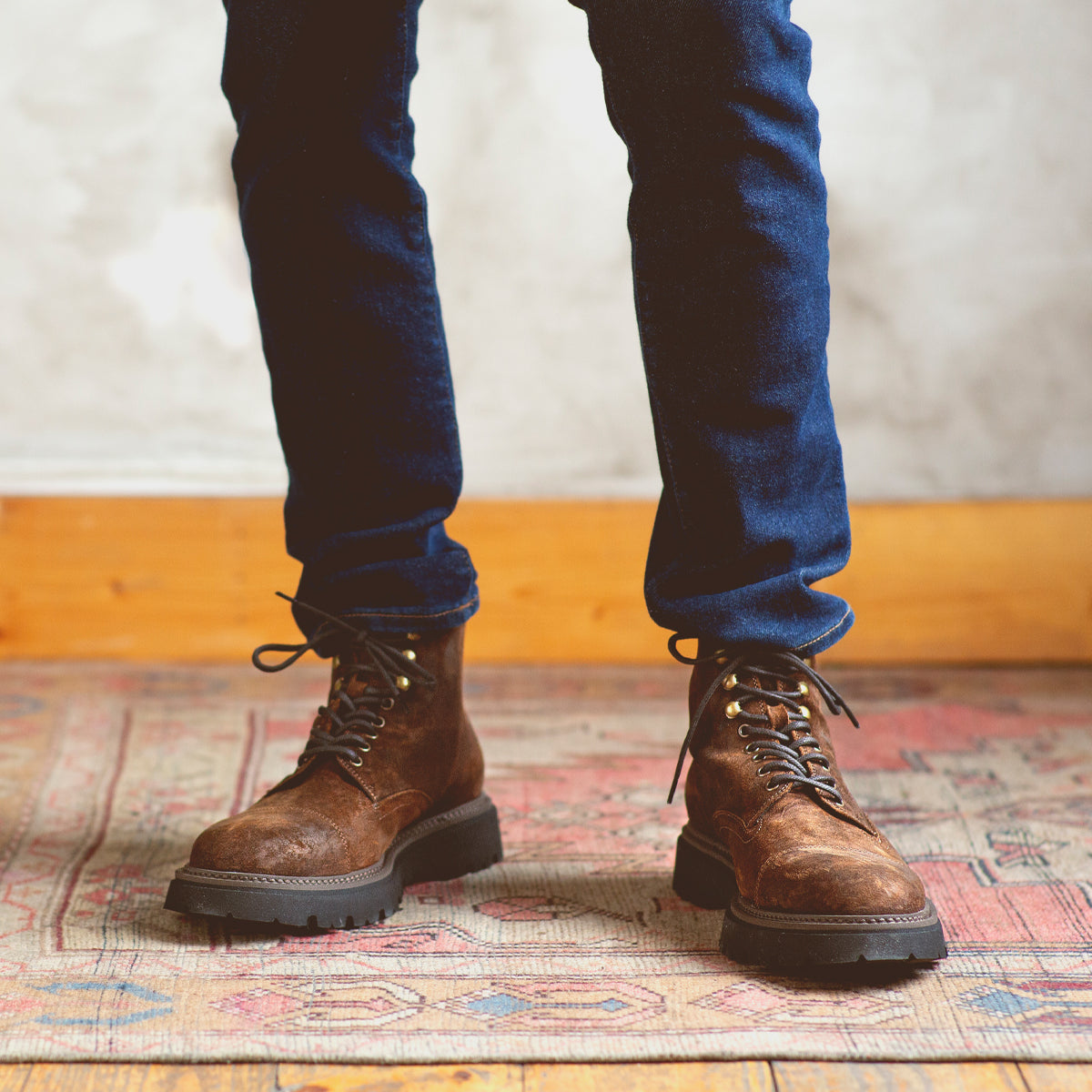 A man in Bed Stu Goer oiled suede leather boots, standing on a rug.