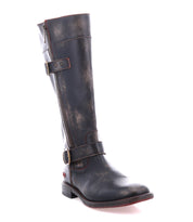 The Bed Stu Gogo Lug is a tall, distressed moto-style leather boot with dual zippers, adjustable straps, and a low heel, displayed against a white background.