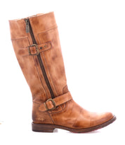 The Bed Stu Gogo Lug is a tall brown moto-style leather boot featuring two buckles, a side zipper, and a low heel, shown in side profile against a white background.