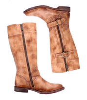 The Bed Stu Gogo Lug is a pair of tall, tan moto-style leather boots with dual zippers and decorative straps, shown from the side on a white background.