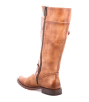 The Bed Stu Gogo Lug is a tall tan moto-style leather boot with dual zippers and a low heel, shown from a three-quarter rear angle against a white background.