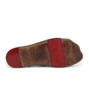 The sole of a brown leather shoe with a red rubber heel and midsection, showing wear and embossed markings, features Bed Stu Hera panels.