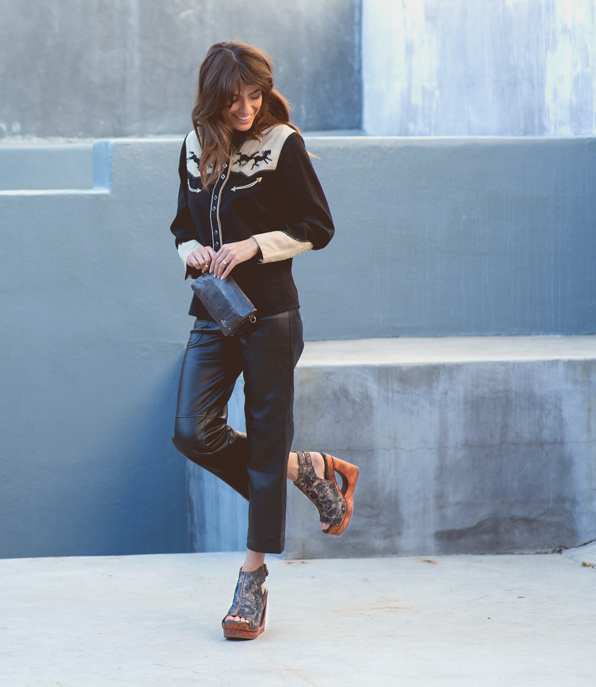 A woman wearing Imelda leather pants and a sweater with a Bed Stu open-toe design wedge.