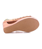 A close-up of the sole of the Bed Stu Imelda wooden wedge sandal with metal rivet details, open-toe design, shown lying on its side.