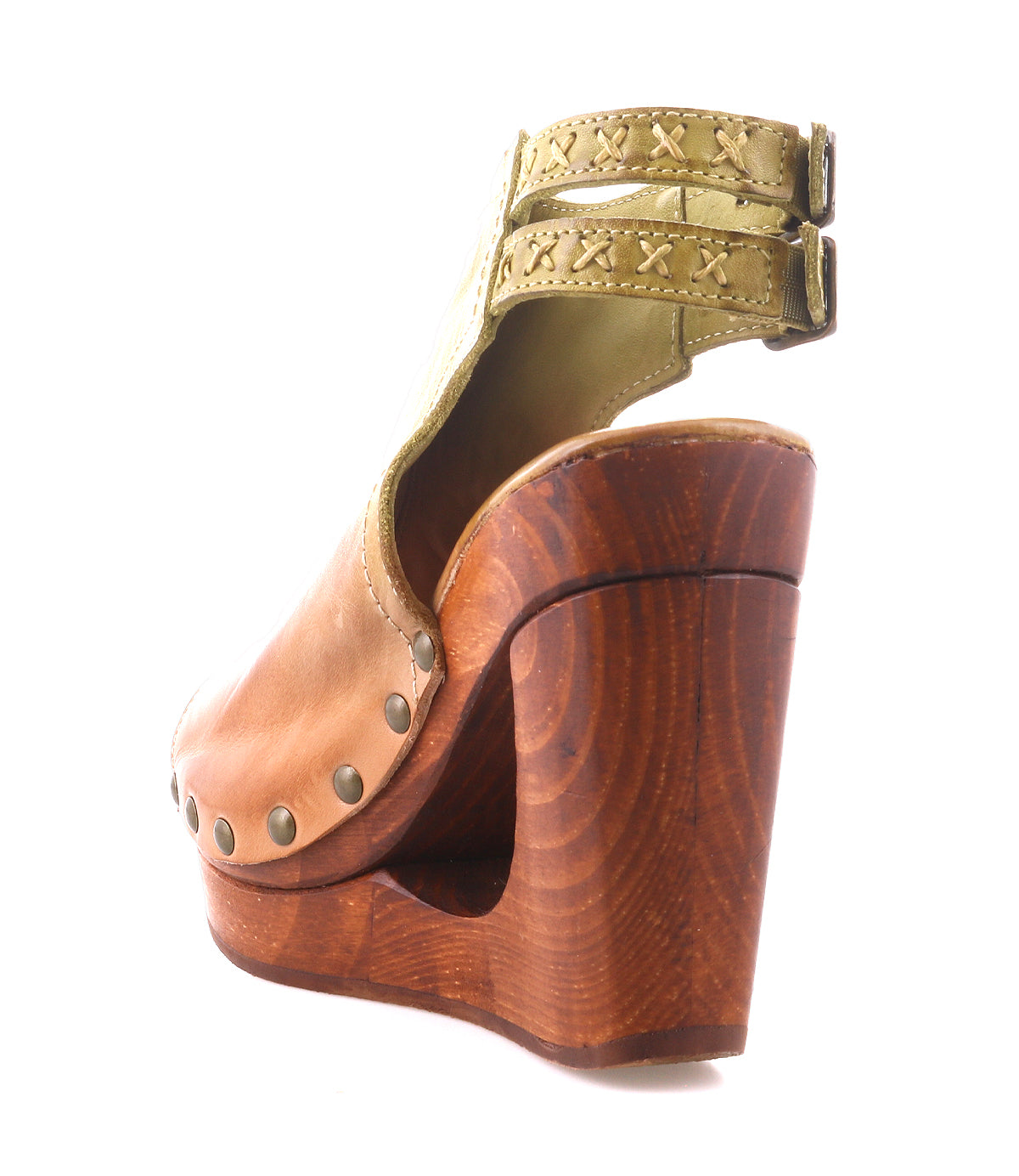 The Imelda by Bed Stu is a tan leather wedge sandal with metal studs, a thick wooden platform heel, an open toe, and two green ankle straps with decorative stitching.