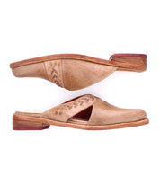 The Bed Stu Jockey is a pair of brown leather slip-on shoes featuring a sleek design, wooden soles, decorative stitching, and cut-out details, displayed in side and top views.