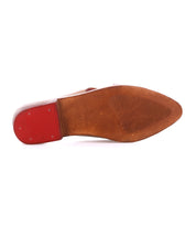 The image shows the sole of the Bed Stu Jockey, a brown leather dress shoe featuring a red heel cap, sleek design, and ribbed texture on the front half.