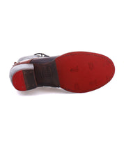 The bottom of the Judgement shoe from Bed Stu showcases a textured red sole, adorned with circular patterns and brand markings typical of a judgment boot.