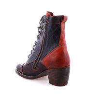 The Judgement boot by Bed Stu features a brown and black leather ankle design with an 8-eye lace-up, a side zipper, and a low block heel, set against a white background.