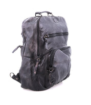 The Lafe by Bed Stu is a spacious black leather backpack featuring multiple zippered compartments, a security tab, top handle, and adjustable shoulder straps, all elegantly displayed against a white background.