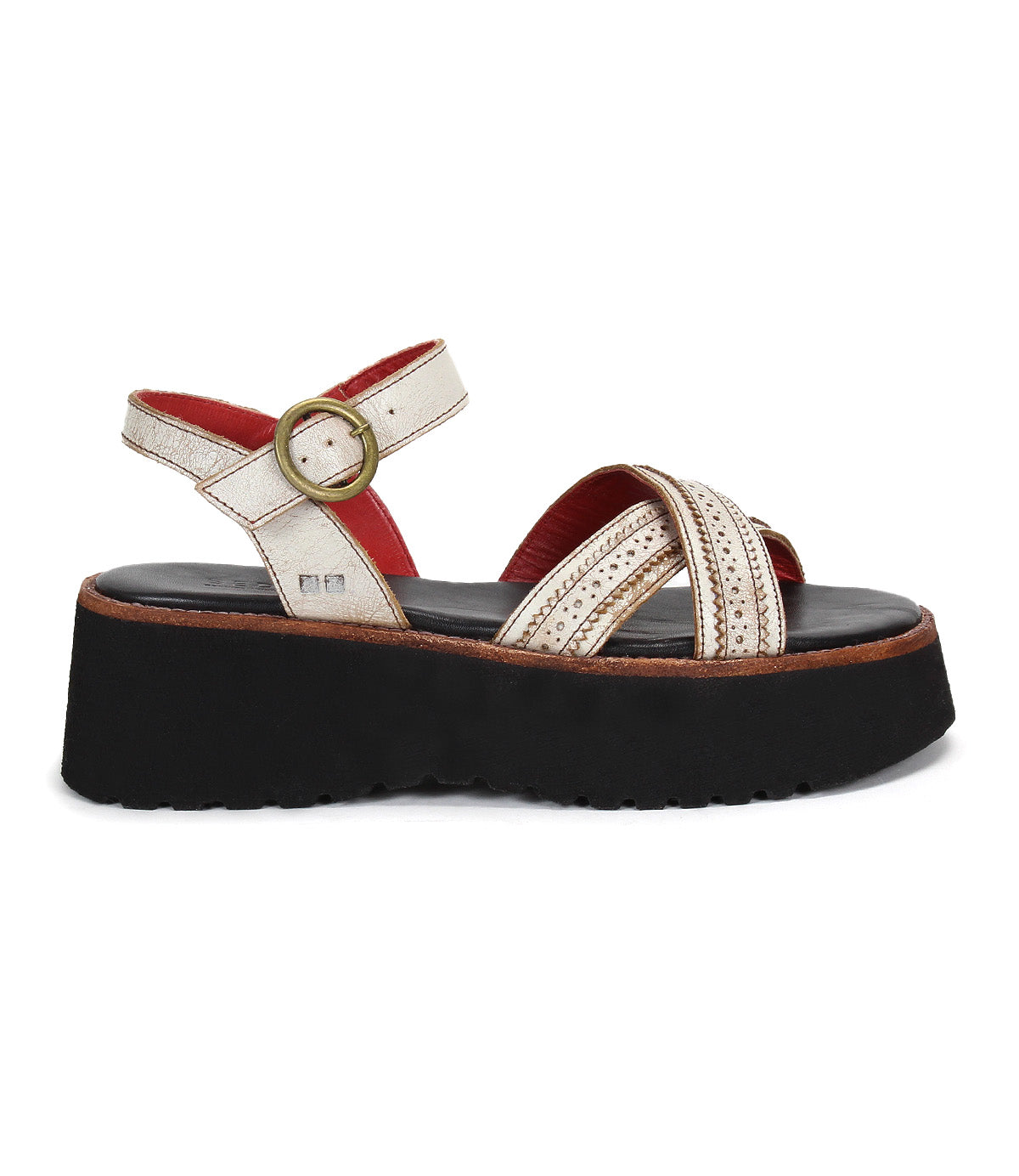 The Bed Stu Lift features a thick black platform sole, metallic gold crisscross straps, an adjustable ankle buckle for comfort, and a striking red inner lining.