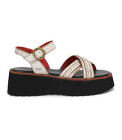 The Bed Stu Lift features a thick black platform sole, metallic gold crisscross straps, an adjustable ankle buckle for comfort, and a striking red inner lining.