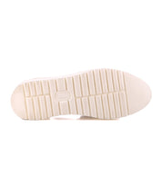 The image shows the bottom view of the Bed Stu Lizzie white rubber shoe sole, featuring a rectangular tread pattern, a small oval label at the center, and a durable outsole inspired by classic platform huarache styles.