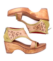 The Bed Stu Locket sandals feature tan and green leather, wooden wedge soles, open toes, laser-cut floral accents, and back zippers. Shown from side and top views.