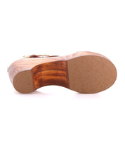 The image displays the bottom view of the Bed Stu Locket sandal, featuring a vintage-inspired wooden heel, textured rubber sole, curved heel design, and artisanal craftsmanship.