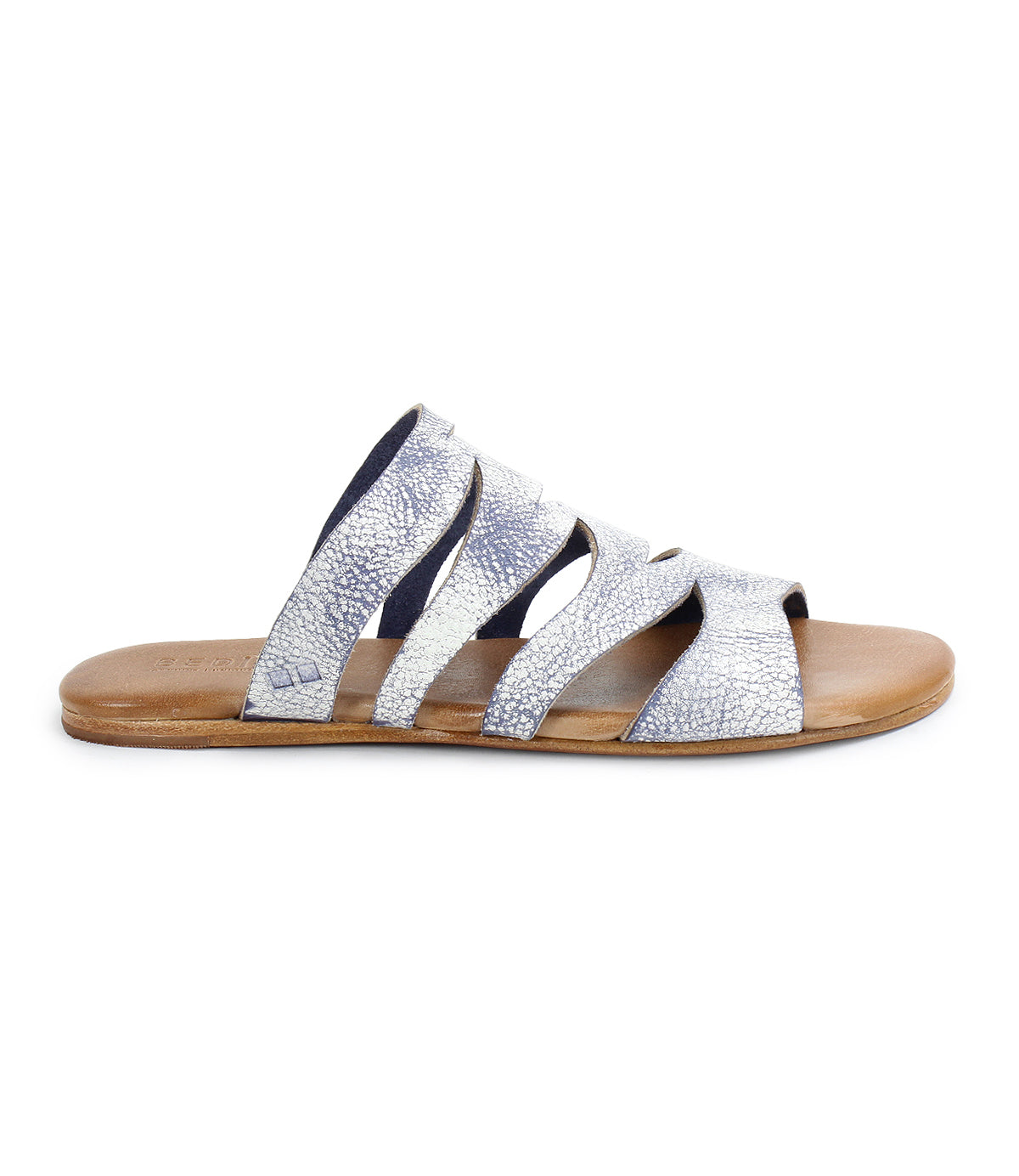 From the side, the Bed Stu Margin showcases a silver strappy slide sandal with a textured leather upper and a brown flat sole, crafted for all-day comfort.