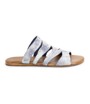 From the side, the Bed Stu Margin showcases a silver strappy slide sandal with a textured leather upper and a brown flat sole, crafted for all-day comfort.