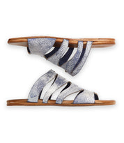 The Bed Stu Margin slide sandals feature silver textured straps with a leather upper and brown soles, shown from the side.