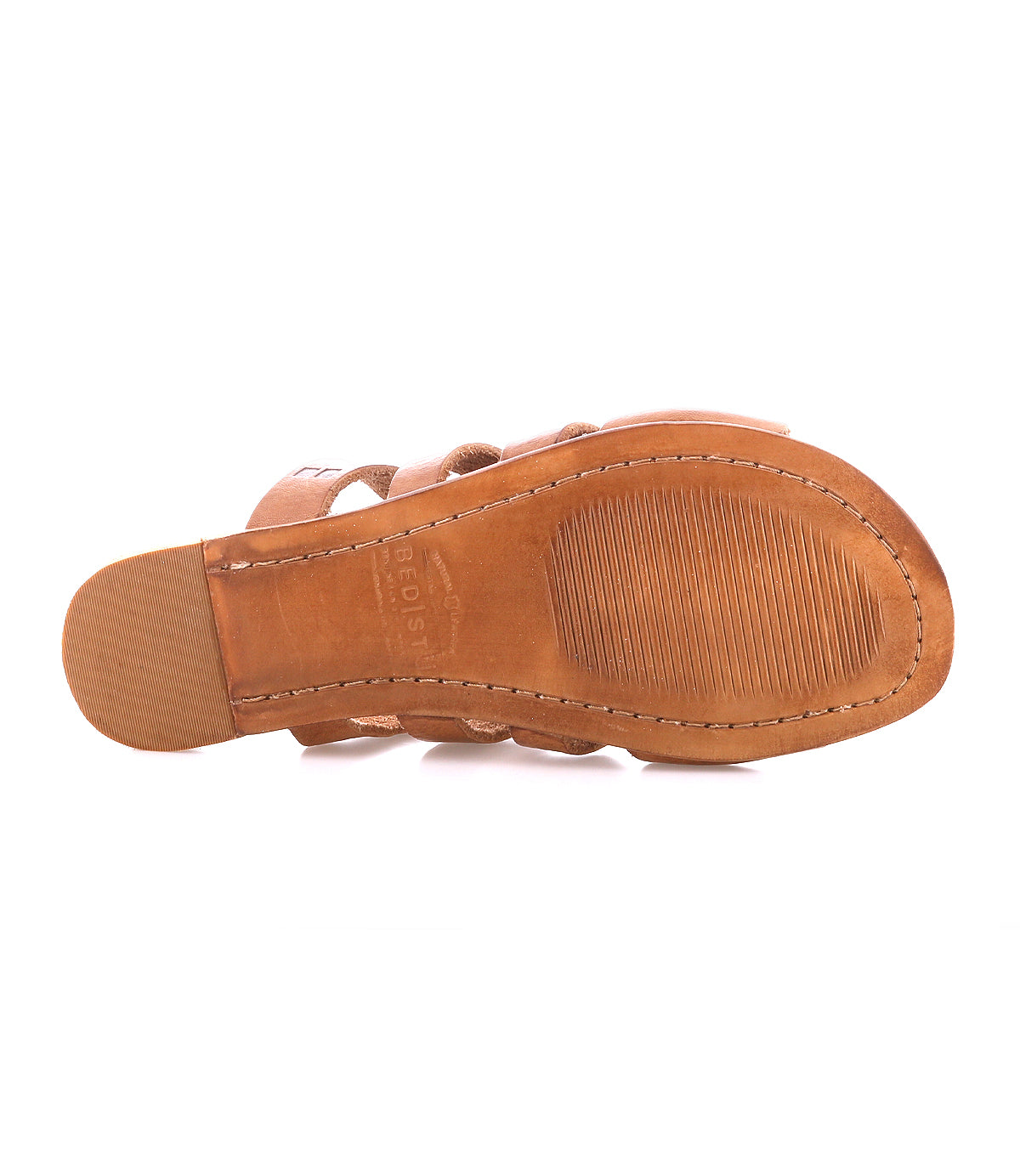 The image displays the sole of Bed Stu's Margin, a brown slide sandal ideal for casual outings. It boasts visible stitching and a ridged pattern on the heel and ball area, paired with an elegant leather upper.