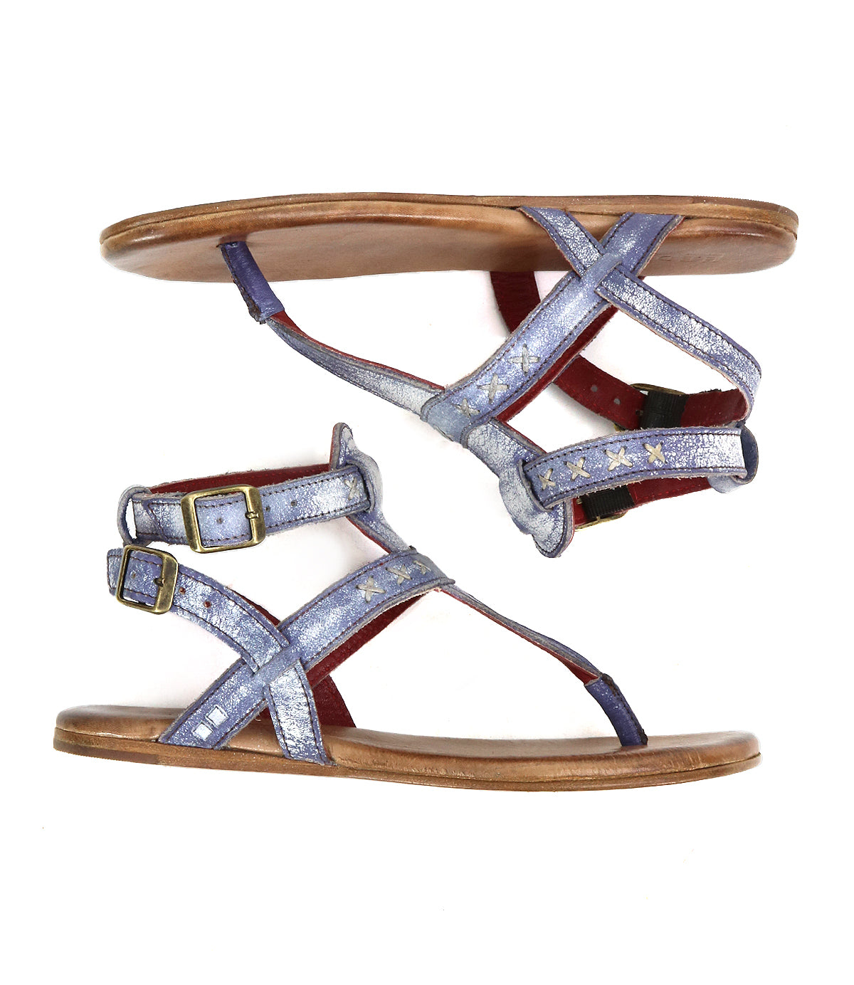 Two metallic blue "Moon" strappy sandals by Bed Stu, with brown soles and star designs, showcasing artisanal craftsmanship, are displayed side by side.