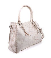 The Rockaway by Bed Stu is a spacious light gray leather handbag featuring dual handles and decorative stitching. It includes a zip-pocket divider and an optional shoulder strap for versatile carrying, all showcased against a white background.
