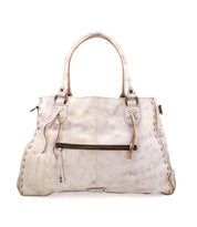 The Rockaway by Bed Stu is a white leather handbag featuring dual handles, a front zipper pocket, and a detachable shoulder strap. It is accented with visible stitching for a stylish finish.