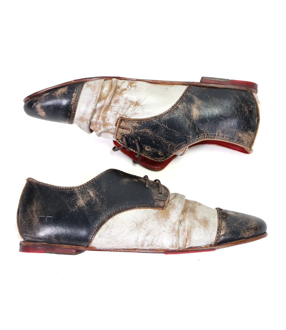 A pair of worn, Bed Stu Rumba II wingtip leather dress shoes with laces on a white background.