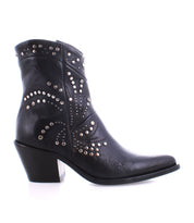 The Sposa ankle boot by Bed Stu features black vegetable-tanned leather with a chunky heel, adorned with decorative silver studs arranged in an elegant swirling pattern.