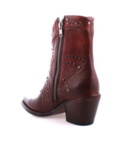 The Sposa by Bed Stu is crafted from brown vegetable-tanned leather and features decorative perforations, a side zipper, and a low heel.