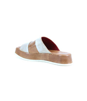 The Bed Stu Vext is a single platform slide sandal featuring a brown leather-wrapped sole and white and beige upper straps with stylish color blocking, displayed against a white background.