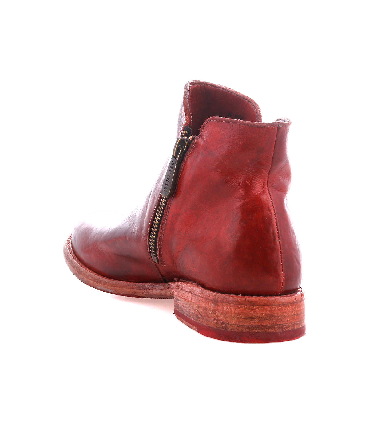 The Bed Stu Yurisa is a red leather ankle boot with a side zipper, low stacked heel, and durable Vibram outsole, shown from the rear at an angle.