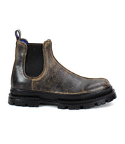 The Bed Stu Accelerate is a rugged brown leather Chelsea boot featuring black elastic side panels, a pull tab, and a thick black lug outsole that adds modern flair to its classic profile.