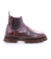 The Bed Stu Accelerate is a brown leather Chelsea boot with elastic side panels, a back pull tab, and a rugged lug outsole for modern flair, shown in profile on a white background.